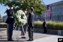 Defense Secretary Ash Carter attends a wreath ceremony during a memorial for the 14th anniversary of the September 11th attacks, Sept. 11, 2015, at the Pentagon.