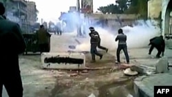 Bức ảnh trích từ video cho thấy những người biểu tình phản đối trong một khu ngoại ô của Damascus che mặt để tránh hơi cay