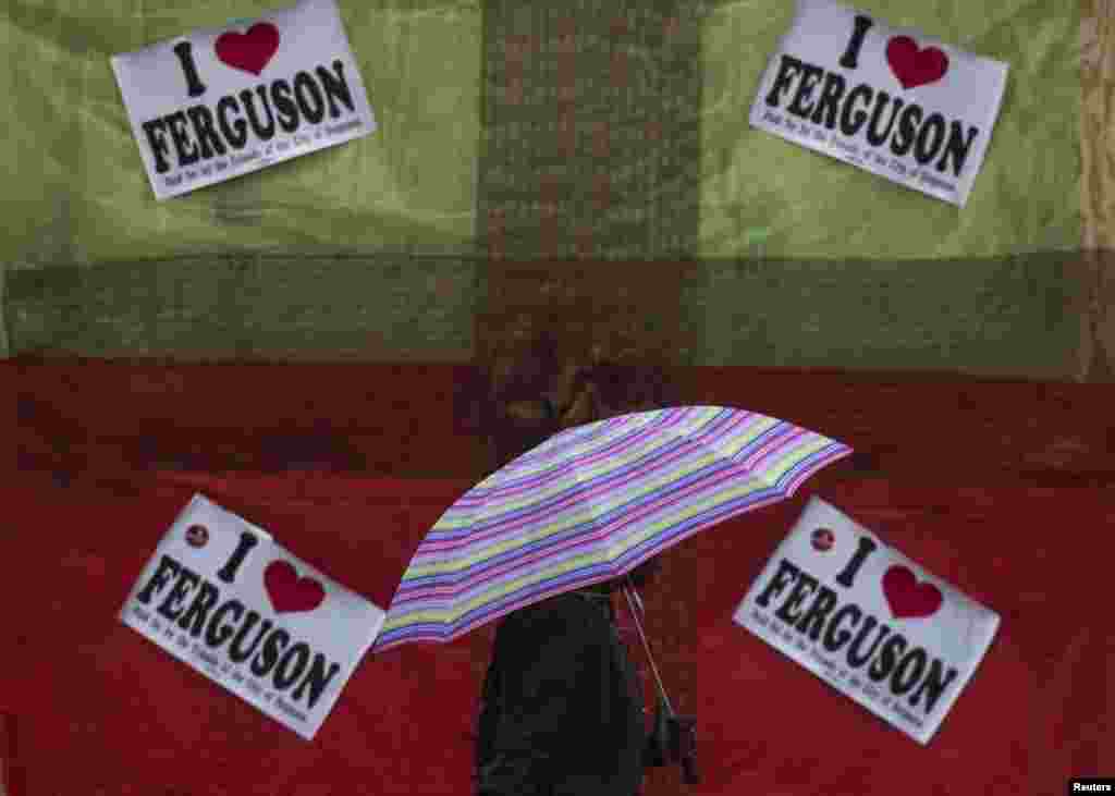 A resident walks past signs with tributes to Michael Brown outside a deserted store in Ferguson, Missouri, Nov. 23, 2014.