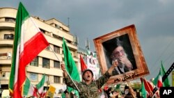 A demonstrator chants slogans while holding up an Iranian national flag during a pro-government rally denouncing last week’s violent protests over a fuel price hike in Tehran, Iran, Nov. 25, 2019. 