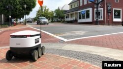 A Starship delivery robot waits to cross an intersection as it drives itself to deliver food amid the coronavirus disease (COVID-19) outbreak in Fairfax, Virginia, U.S., May 15, 2020. (REUTERS/Julio-Cesar Chavez)