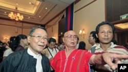 General Mutu Saipo (C) from the Karen National Union talks with a member of the Burma government negotiation team during a welcome dinner ceremony at Sedona hotel in Rangoon, Burma, April 5, 2012.
