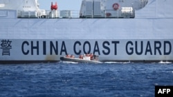 Sebuah perahu karet meninggalkan kapal penjaga pantai China di dekat Scarborough Shoal yang dikuasai China di Laut China Selatan. (Foto: AFP)