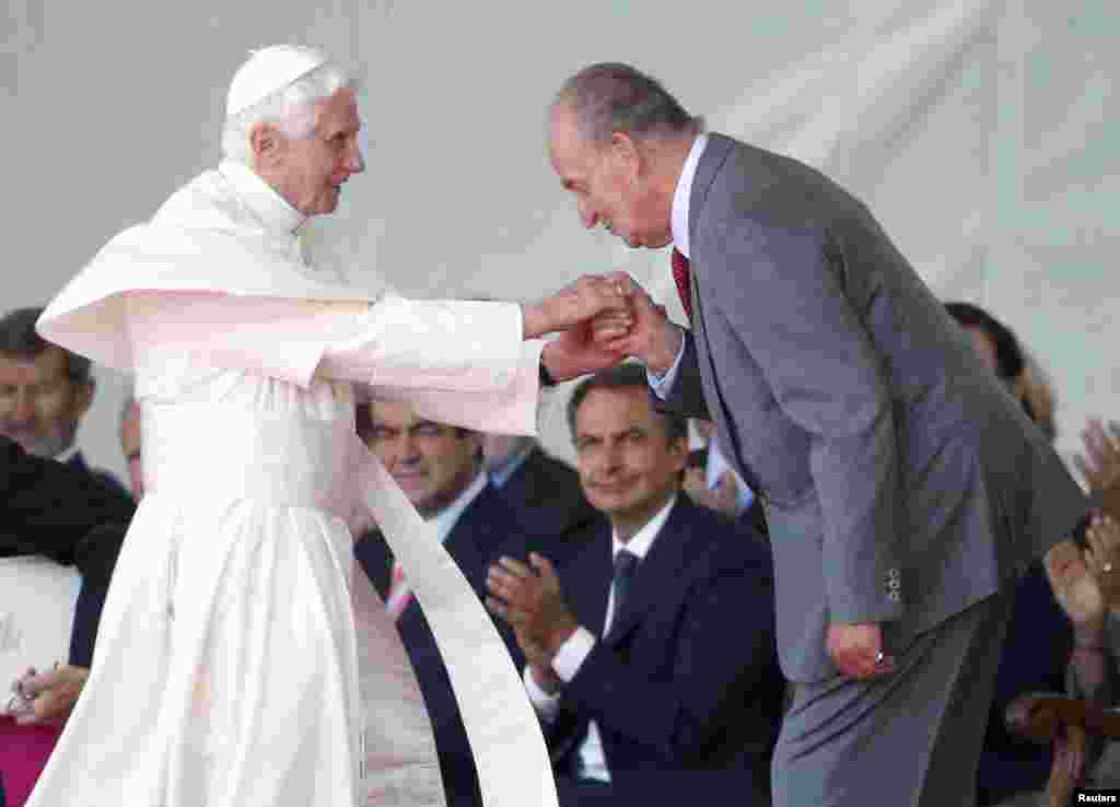 Spain's King Juan Carlos kisses the ring of Pope Benedict next to Spain's Prime Minister Jose Luis Rodriguez Zapatero at Madrid's Barajas airport, August 18, 2011. 