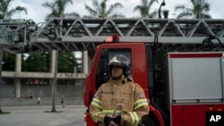 Firefighter Elielson Silva arrives to play his trumpet from the top of a ladder for residents cooped up at home, during a lockdown to help contain the spread of the new coronavirus in Rio de Janeiro, Brazil, April 5, 2020.