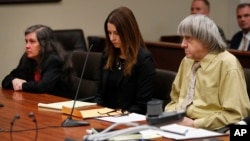 David Turpin, right, his wife, Louise, left, and attorney Allison Lowe listen during a courtroom hearing, Feb. 22, 2019, in Riverside, Calif. The couple, who shackled some of their 13 children to beds and starved them, pleaded guilty of torture and other abuse.