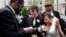 Bishop Harry R. Jackson Jr. of Beltsville, Md., left, prays with Jonathan Paul Ganucheau, 24, and Denise Buckbinder Ganucheau, 26, both of Dallas, Texas, before performing a religious wedding ceremony in Washington, May 5, 2009. 