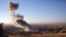 FILE - Smoke believed to be from an airstrike billows over the northern Iraqi town of Sinjar, Nov. 12, 2015. A man on an IS-released video denounced such strikes by "infidels."