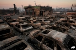 Mobil-mobil hangus terbakar di dalam dealer mobil setelah kebakaran Eaton di Altadena, California, 10 Januari 2025. (Foto: AP)