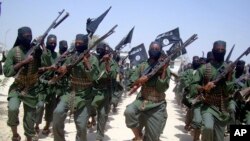 FILE - In this Thursday, Feb. 17, 2011 file photo, al-Shabab fighters march with their weapons during military exercises on the outskirts of Mogadishu, Somalia.