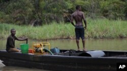 Suspected oil thieves ride a wooden boat full of stolen crude oil on the creeks of Bayelsa, Nigeria, May 18, 2013.