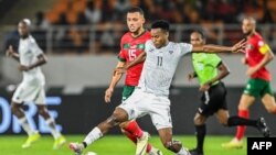 FILE — South African forward Themba Zwane fights for the ball against Moroccan midfielder Selim Amallah during the 2023 Africa Cup of Nations Round of 16 match, January 30, 2024