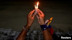 Una mujer sostiene una vela durante una vigilia en honor a los venezolanos detenidos durante las protestas contra los resultados de las elecciones presidenciales, en la Universidad Central de Venezuela en Caracas, Venezuela, el 17 de diciembre de 2024. REUTERS/Gaby Oraa