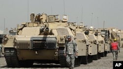 U.S. soldiers walk past tanks at a courtyard at Camp Liberty in Baghdad. U.S troops are scheduled to pull out of the country by the end of this year, according to a 2008 security pact between the U.S. and Iraq. (File September 30, 2011).