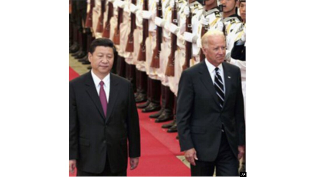 Chinese Vice President Xi Jinping, left, accompanies his U.S. counterpart Joseph Biden to review an honor guard during a welcoming ceremony inside the Great Hall of the People in Beijing, August 18, 2011