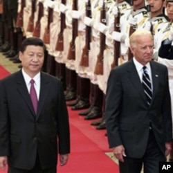 Chinese Vice President Xi Jinping, left, accompanies his U.S. counterpart Joseph Biden to review an honor guard during a welcoming ceremony inside the Great Hall of the People in Beijing, August 18, 2011