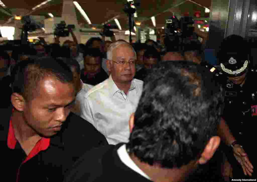 Malaysian Prime Minister Najib Razak, center, arrives at the reception center and holding area for family and friend of passengers aboard a missing Malaysia Airlines flight MH370, at Kuala Lumpur International Airport in Sepang, outside Kuala Lumpur.