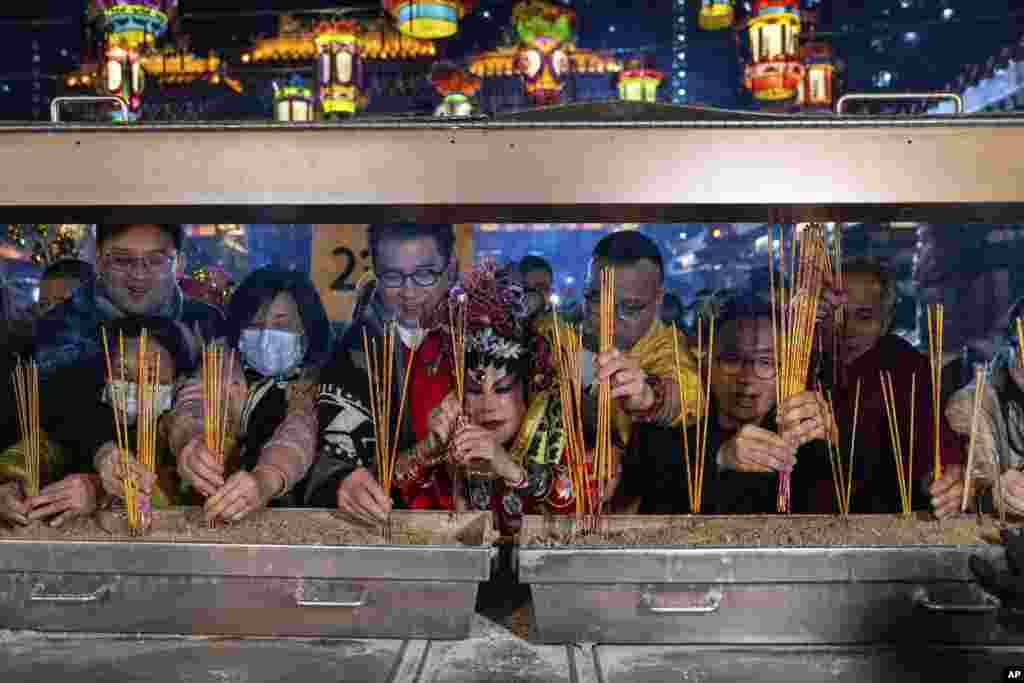 Actor Lana Wong Wai Lin, center, and other worshipers burn incense at Wong Tai Sin Temple to welcome the Lunar New Year of the Snake in Hong Kong.