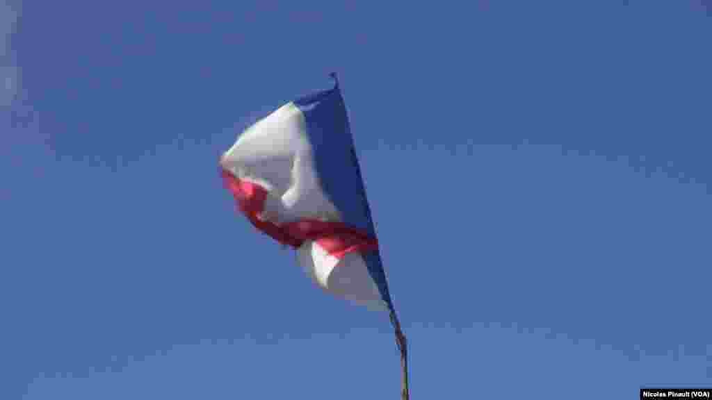 Le drapeau français flotte au-dessus d&#39;une tente dans la &quot;jungle&quot;. Ce camp est situé aux abords de Calais dans le nord de la France, 13 octobre 2015 (Nicolas Pinault/VOA). &nbsp;