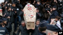 Pallbearers carry the casket of Charlie Hebdo cartoonist Bernard Verlhac, known as Tignous, decorated by friends and colleagues of the satirical newspaper Charlie Hebdo, at Montreuil city hall east of Paris, Jan. 15, 2015.