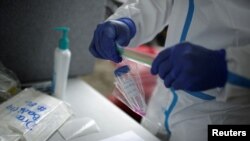 Un trabajador de la salud conserva una muestra de una prueba tomada a un residente de San José, Costa Rica, por la enfermedad del coronavirus (COVID-19) en julio de 2020.