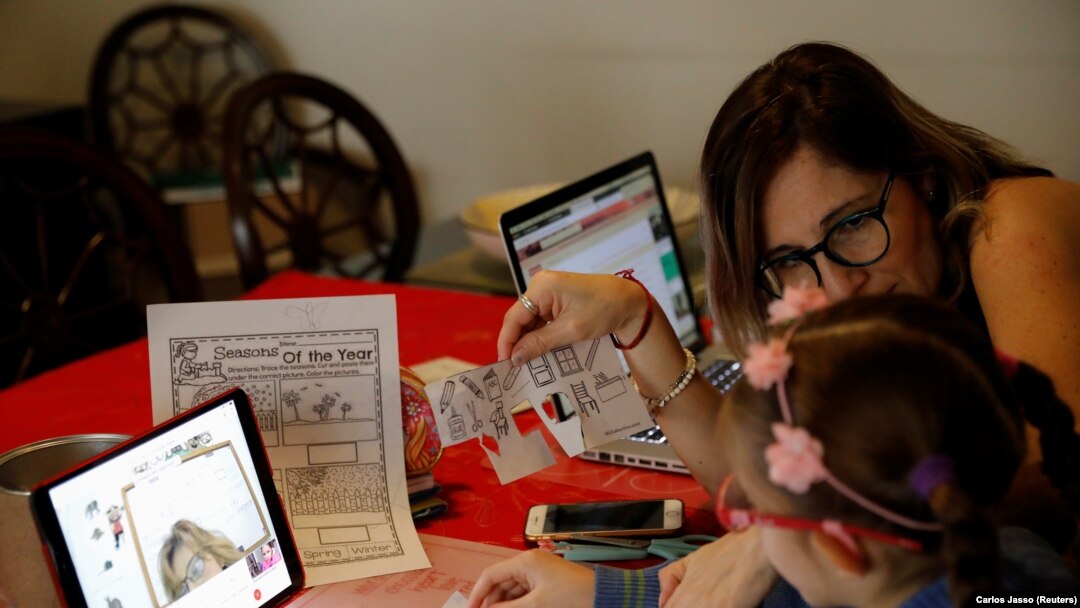 Isabel Martin del Campo, membantu putrinya Ines, 6 tahun, di kelas bahasa Inggrisnya. Jutaan siswa kembali ke kelas secara virtual setelah sekolah ditutup sejak Maret karena wabah Covid-19, Mexico City, Meksiko, 24 Agustus 2020. (Foto: REUTERS/Carlos Jass