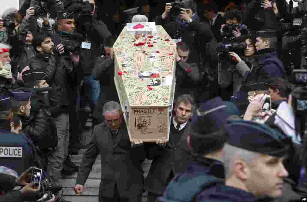 Pallbearers carry the casket of Charlie Hebdo cartoonist Bernard Verlhac, known as Tignous, decorated by friends and colleagues of the French satirical weekly, at the city hall of Montreuil, outside of Paris. Funerals are being held for last six staff members of the satirical weekly, who were killed last week in a terror attack at their office in Paris.
