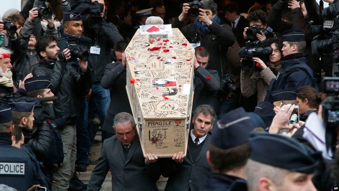 Para pelayat mengangkat peti jenazah kartunis Charlie Hebdo, Bernard Verlhac, yang dikenal dengan panggilan Tignous, yang didekorasi oleh rekan dan sahabat sekantornya saat dibawa melewati balai kota Montreuil, sebelah timur Paris, 15 Januari 2015 (Foto: dok).