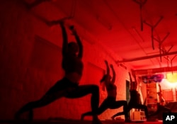 FILE - Women attend a yoga master class at Shogun sports center in Kyiv, Ukraine on Nov. 29, 2024. (AP Photo/Evgeniy Maloletka)