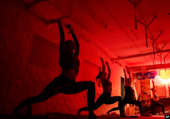 FILE - Women attend a yoga master class at Shogun sports center in Kyiv, Ukraine on Nov. 29, 2024. (AP Photo/Evgeniy Maloletka)