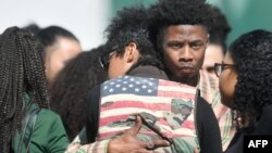 ບັນດາຜູ້ໄວ້ທຸກກອດກັນ ໃນຂະນະທີ່ເຂົາເຈົ້າເດີນທາງເຂົ້າ
ພິທີສົ່ງສະການຂອງທ້າວ ສເຕເຟິນ ຄລາກ ໃນເມືອງ ຊາຄຣາ
ເມັນໂຕ, ລັດຄາລິຟໍເນຍ. 29 ມີນາ, 2018.