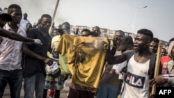 Les supporters brûlent un t-shirt avec les mots "Joseph Kabila" imprimé lors d'un rassemblement de l'opposition à Kinshasa, le 29 septembre 2018.