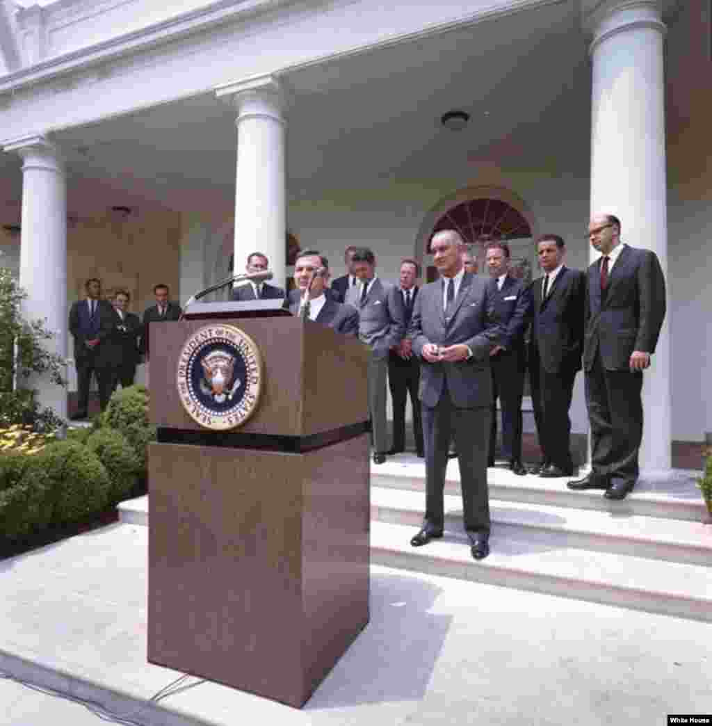 1964年6月15日，在美国总统约翰逊注视下，大卫·洛克菲勒在白宫玫瑰园宣布国际高级经理服务团成立。（白宫图片）