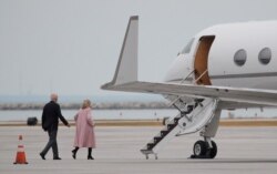 Democratic U.S. presidential candidate Joe Biden walks across the airport tarmac to his campaign plane with his wife, Jill, to depart after canceling his primary night rally over coronavirus concerns in Cleveland, Ohio, March 10, 2020.