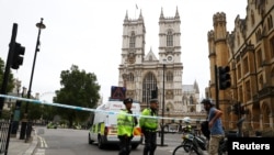 Polisi berdiri di belakang garis pembatas pasca insiden 'mobil tabrak pejalan kaki' di luar Gedung Parlemen di Westminster, London, Inggris, 14 Agustus 2018.
