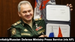 俄罗斯国防部长绍伊古在莫斯科与中国国防部长魏凤和举行视频会谈期间出示俄中军事合作协议上他的签名。（2021年11月23日）