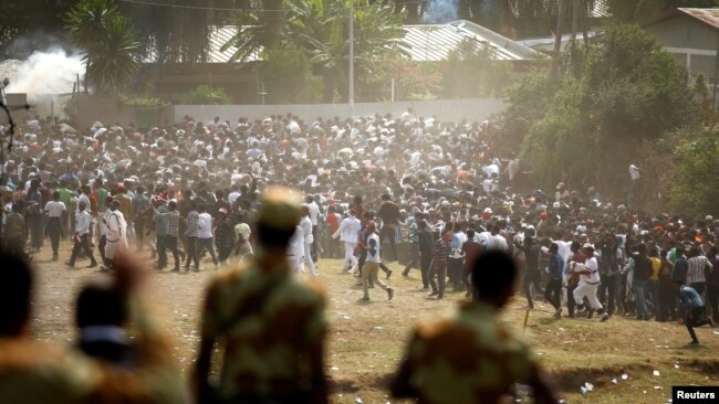 FILE - Protesters run from tear gas launched by security personnel during the Irecha, the thanksgiving festival of the Oromo people in Bishoftu town of Oromia region, Ethiopia, Oct. 2, 2016. 