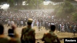 FILE - Protestors run from tear gas launched by security personnel during the Irecha, the thanks giving festival of the Oromo people in Bishoftu town of Oromia region, Ethiopia, Oct. 2, 2016. 