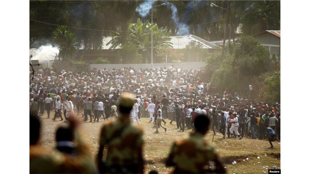FILE - Protestors run from tear gas launched by security personnel during the Irecha, the thanksgiving festival of the Oromo people, in Bishoftu town of Oromia region, Ethiopia, Oct. 2, 2016.