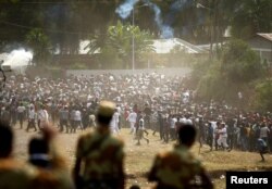 FILE - Protestors run from tear gas launched by security personnel during the Irecha, the thanksgiving festival of the Oromo people, in Bishoftu town of Oromia region, Ethiopia, Oct. 2, 2016.