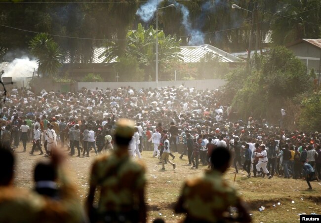 FILE - Protestors run from tear gas launched by security personnel during the Irecha, the thanksgiving festival of the Oromo people, in Bishoftu town of Oromia region, Ethiopia, Oct. 2, 2016.