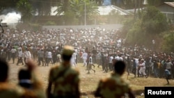 FILE - Protesters run from tear gas launched by security personnel during the Irecha, the thanksgiving festival of the Oromo people in Bishoftu town of Oromia region, Ethiopia, Oct. 2, 2016. 