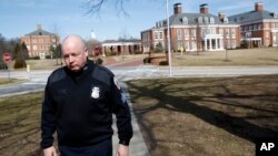 FILE - In this Feb. 26, 2019 photo, Sgt. Jason Cowger, with Johns Hopkins University's Campus Safety and Security department, walks on the university's campus in Baltimore. 