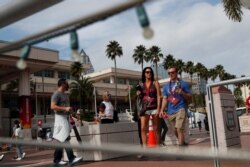 People walk outside the Tampa Convention Center a day before Super Bowl LV, as the spread of COVID-19, continues in Tampa, Fla., Feb. 6, 2021.