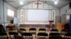 FILE - Calligraphy reading, "All nations belong to the Lord arising to shine," at left, and "Jesus' salvation spreads to the whole world," at right, are displayed in a house church shut down by authorities near Nanyang, China, June 4, 2018.