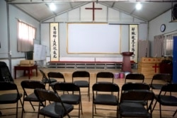 FILE - Calligraphy reading, "All nations belong to the Lord arising to shine," at left, and "Jesus' salvation spreads to the whole world," at right, are displayed in a house church shut down by authorities near Nanyang, China, June 4, 2018.