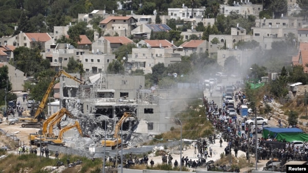 FILE — Israeli heavy machinery demolish vacant apartment blocs by order of Israel's high court, in the West Bank Jewish settlement of Beit El near Ramallah July 29, 2015. (Reuters) 