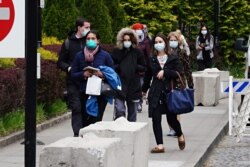 FILE - Medical workers at New York-Presbyterian/Weill Cornell Medical Center change shifts during the coronavirus pandemic April 17, 2020, in New York City.