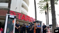Policajci stoje ispred prodavnice iz lanca Target za vreme protesta grupe građana preko puta ulice, 1. juna 2023. u Majamiju. 