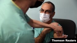 دکتر گای خوشن، مدیر بخش کووید۱۹ بیمارستان ایخیلف، دومین دز واکسن ویروس کرونا را دریافت می‌کند - تل آویو، اسرائیل